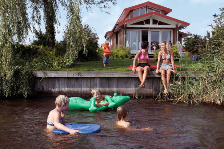 Kinderen spelen in het water bij een vakantiehuis op Waterpark Zwartkruis