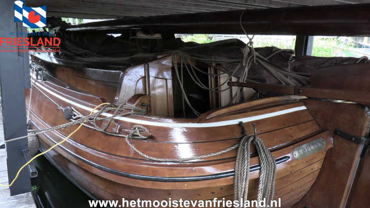 Houten skûtsje Aebelina met gestreken mast onder een afdak bij het Skûtsjemuseum in Earnewâld Houten skûtsje Aebelina met gestreken mast onder een afdak bij het Skûtsjemuseum in Earnewâld
